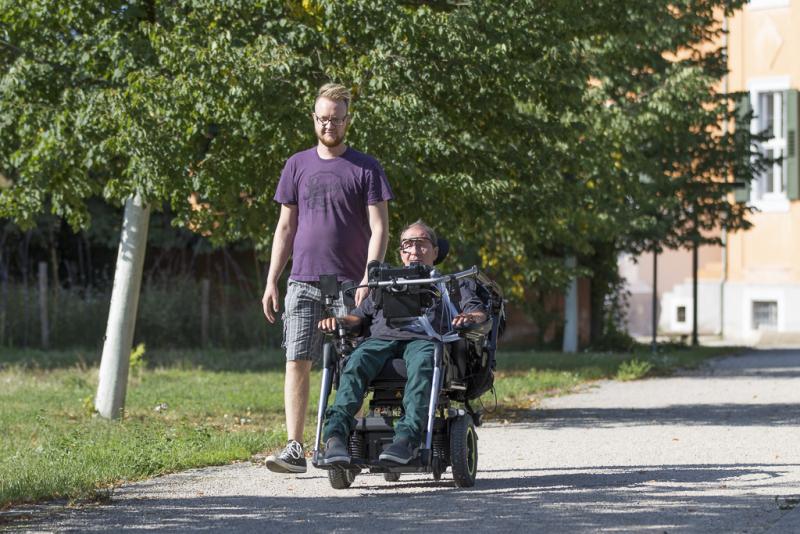 Wheelchair user driving outside with the glasses MyEcc Pupil